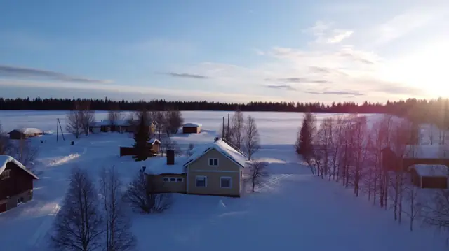 Aerial view of the house, fields and frozen lake in winter