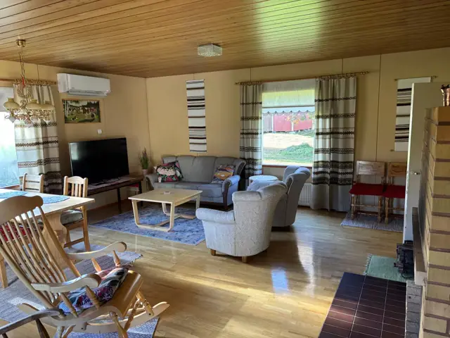 Bright living room with sofa, TV and dining area